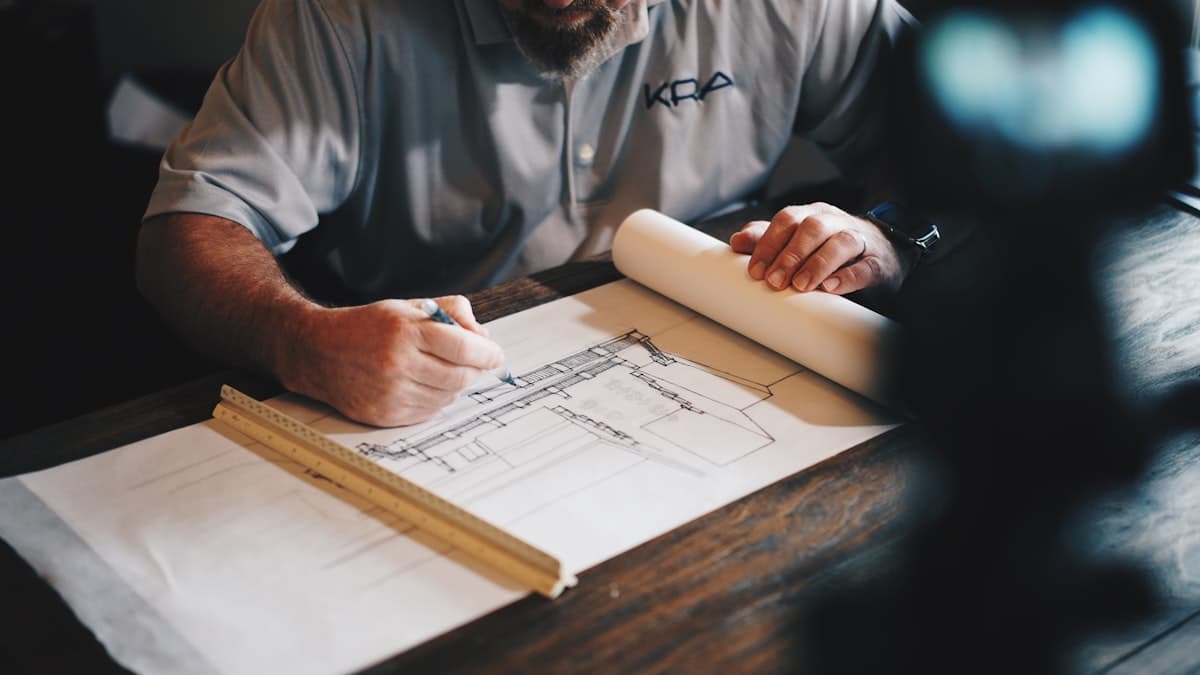 An experienced builder drafting construction plans by hand — craft and precision from the ground up.